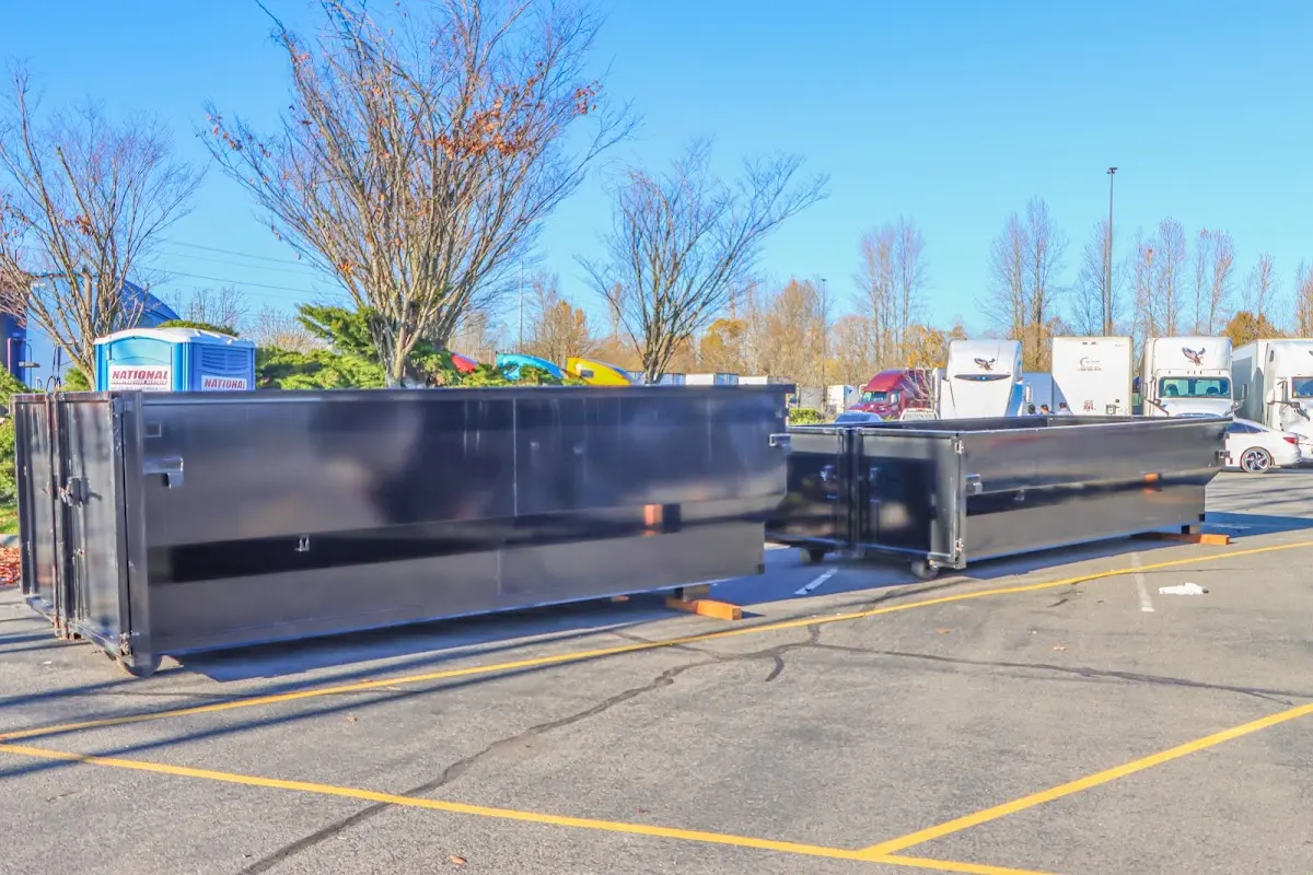 Professional dumpster rental service with roll-off container on residential driveway in East Rockaway
